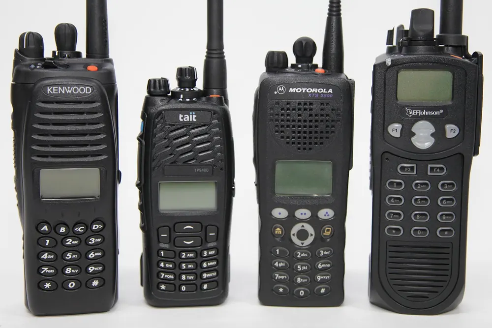 Four handheld digital police radios from Kenwood, Tait, Motorola and EF Johnson