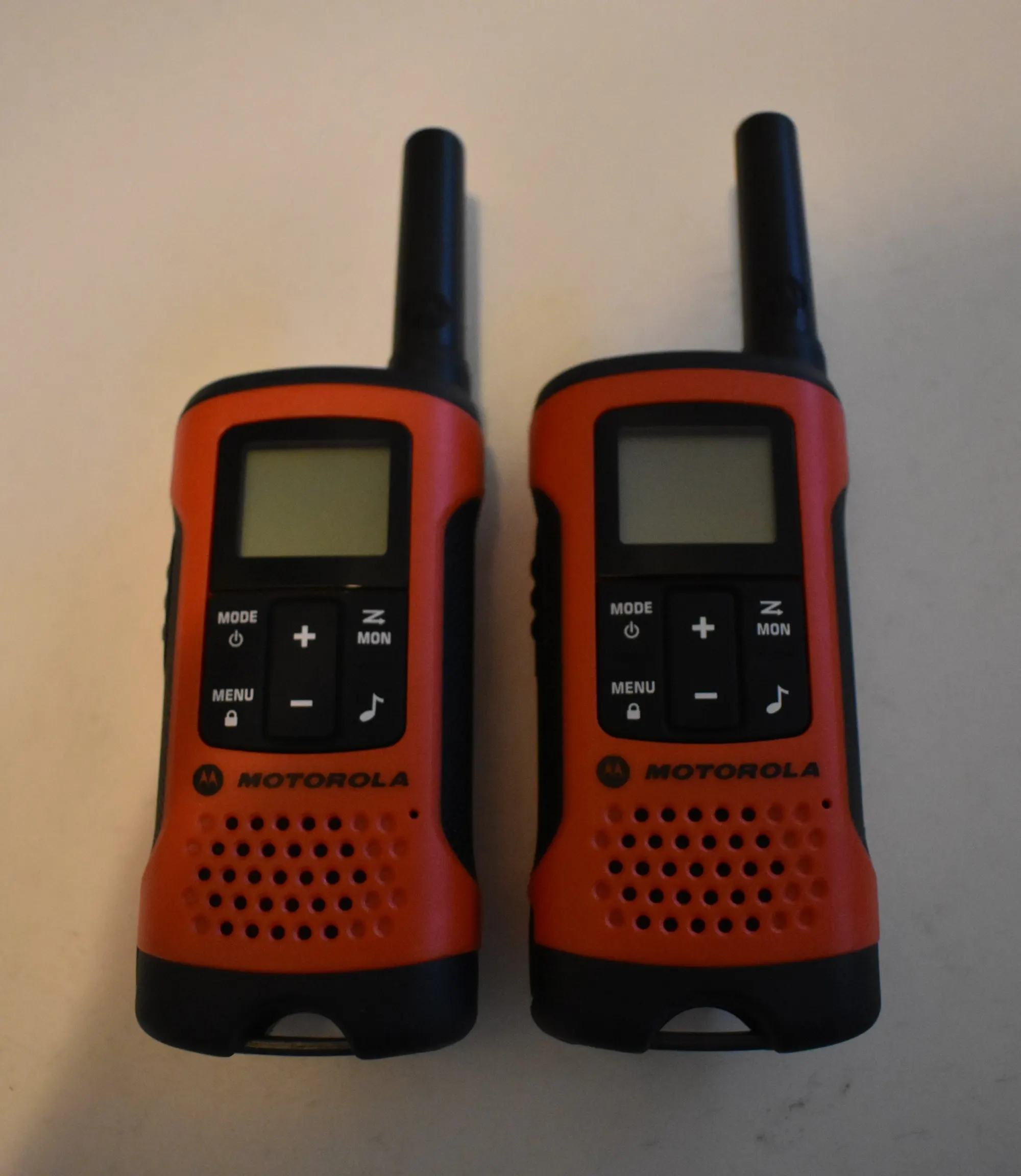 Two orange Motorola Talkabout walkie-talkies side by side