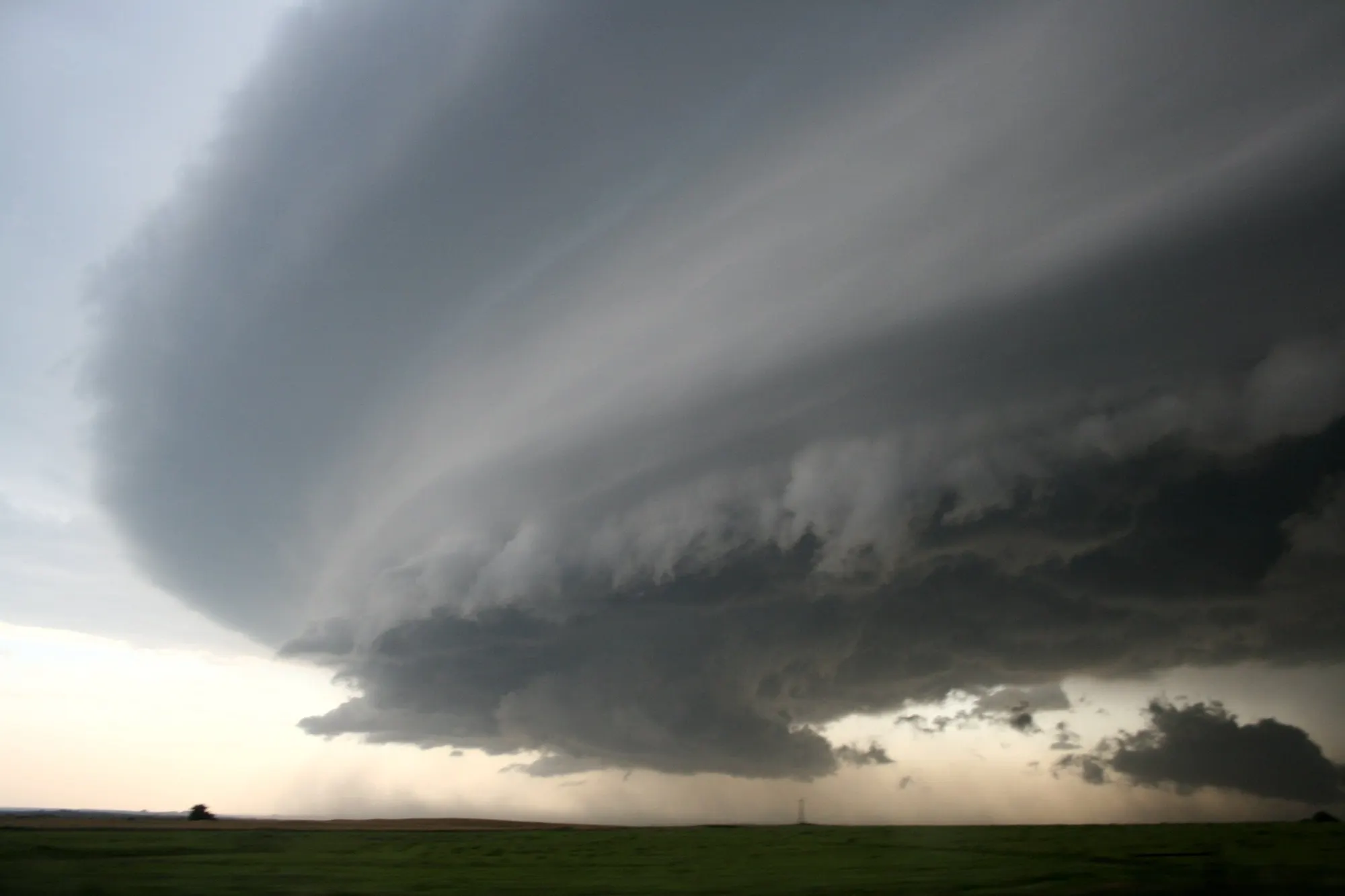 A wide shelf cloud from a supercell storm over open plains